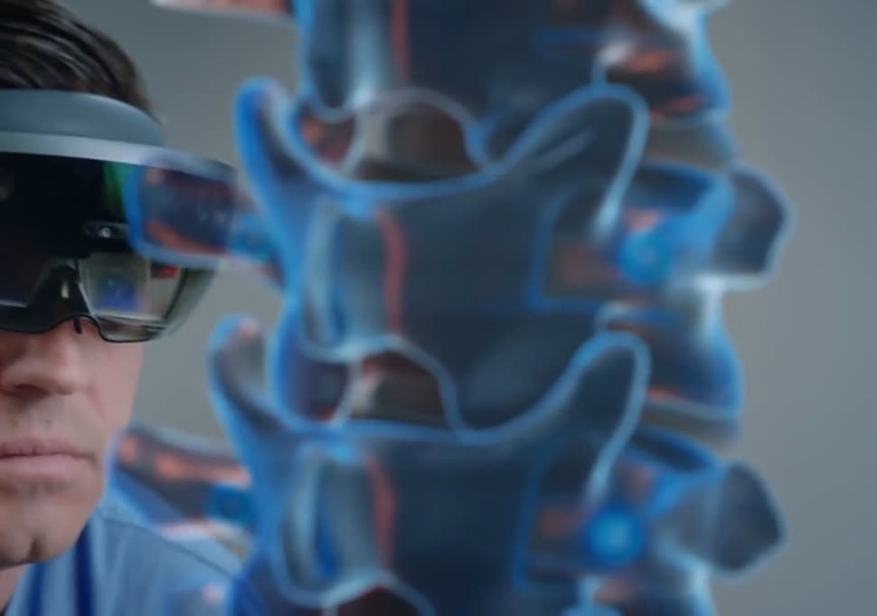 A HoloLens wearer with a translucent hologram of a spine floating in their field of view